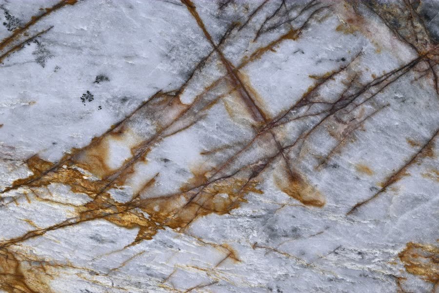 Nebula Crystal — close view of the stone surface. A pale ground threaded with amber and gold.