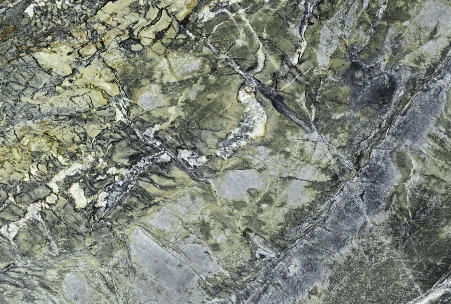 Tempest Green — close view of the stone surface. Dark green ground fractured by grey-white structure.